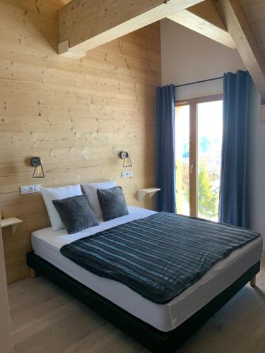 une chambre avec un grand lit et une fenêtre dans l'établissement SKI LODGE, à La Toussuire