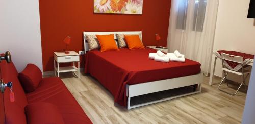 una camera da letto con un letto con lenzuola rosse e cuscini arancioni di AleMar a Porto Cesareo