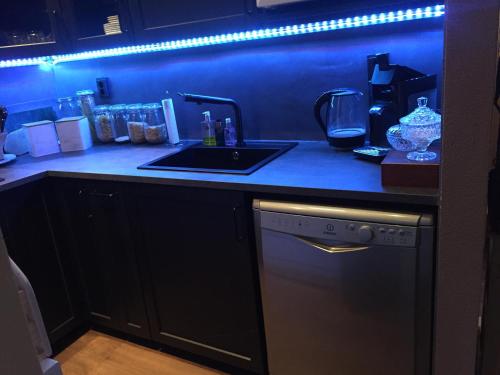 a kitchen with a counter with a sink and a stove at Rumah kita, bungalow met 2 slaapkamers in het mooie Drenthe in Erm