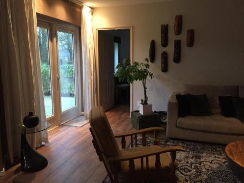 a living room with a couch and a table at Rumah kita, bungalow met 2 slaapkamers in het mooie Drenthe in Erm