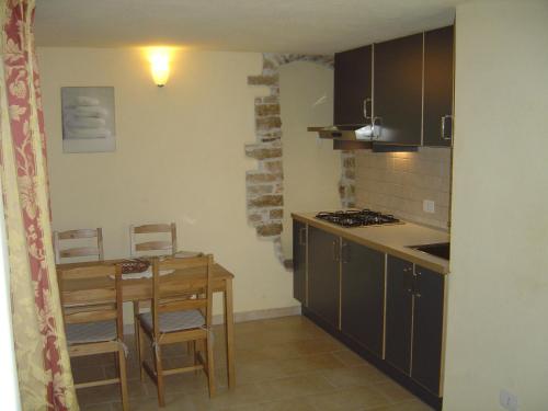 a small kitchen with a table and a table and chairs at Dimora Antico Forno Soprano in Maschito