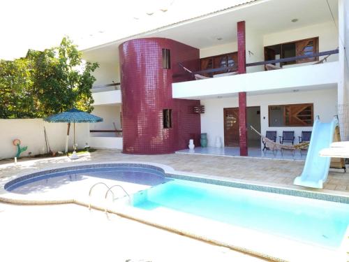 una piscina frente a una casa con un edificio en Pousada Praia da Barra, en Barra de São Miguel