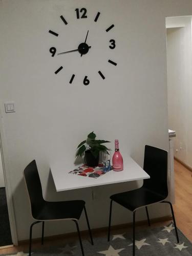 a white table with chairs and a clock on a wall at StarHomes Hallituskatu 23 in Oulu