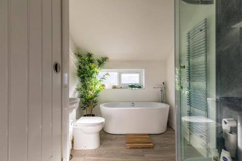 a bathroom with a white tub and a toilet at The Hollywood - Beautiful 3 Bedroom House in Cardiff