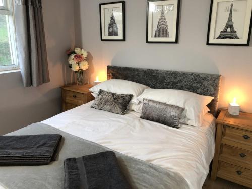 um quarto com uma grande cama branca e 3 almofadas em Ash rock House em Haverfordwest