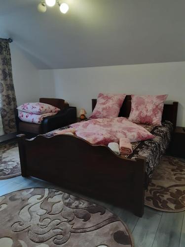 a bedroom with a bed with pink sheets on it at NICO-ȘTEF in Vatra Dornei