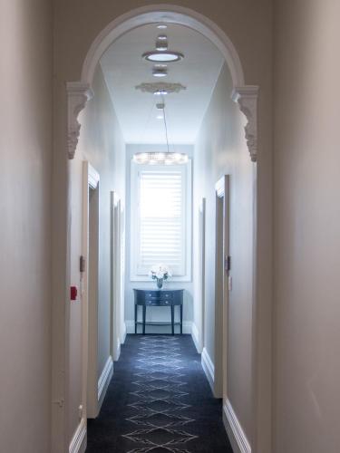 a hallway with a window and a vase of flowers at Royal Hotel Randwick in Sydney