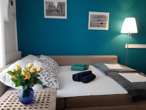 Un dormitorio con una cama con un jarrón de flores. en CHIARA, en Crikvenica