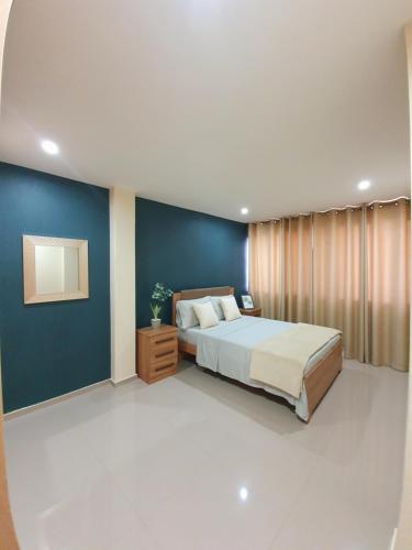ein Schlafzimmer mit einem Bett und einer blauen Wand in der Unterkunft kelly's House Plateau City Center in Praia
