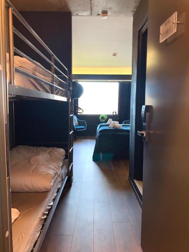 a room with bunk beds with a person laying on a bed at Oscarsborg Castle Hotel & Resort in Drøbak