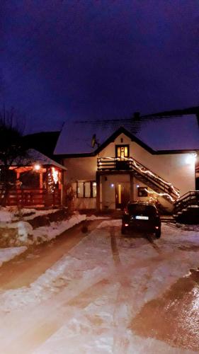 a house with a car parked in a parking lot at night at Apartment Sijakovic in Mokra Gora