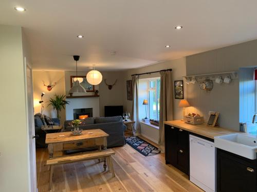 a kitchen and living room with a couch and a table at The Old Dairy at Walkmill Farm in Bushmills