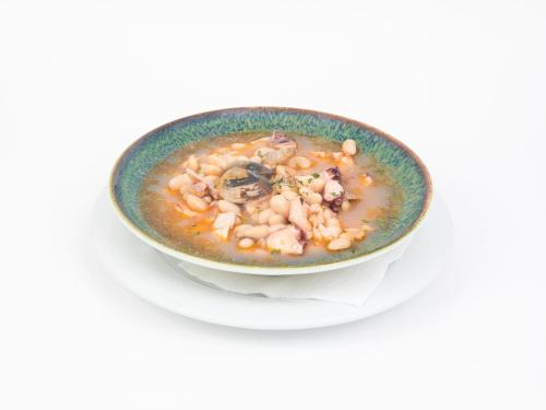 a bowl of seafood soup on a white plate at Hotel Roma in Sarria