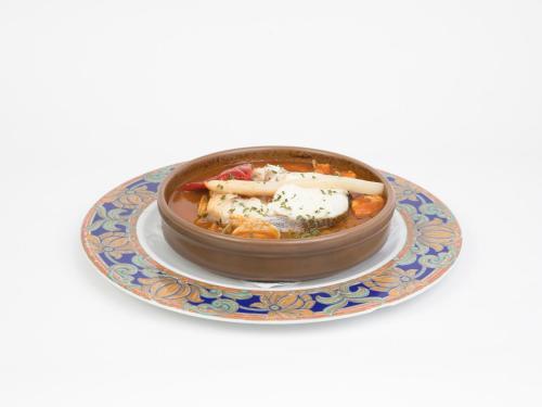 a bowl of food sitting on a plate at Hotel Roma in Sarria