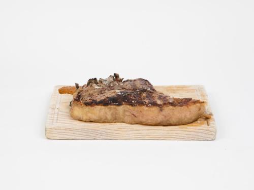 a piece of meat sitting on a cutting board at Hotel Roma in Sarria
