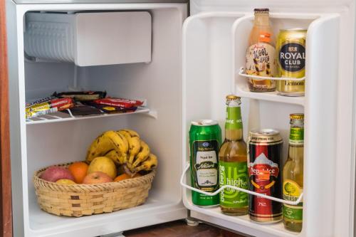 an open refrigerator with a basket of fruit and drinks at Himalayan Suite Hotel in Kathmandu