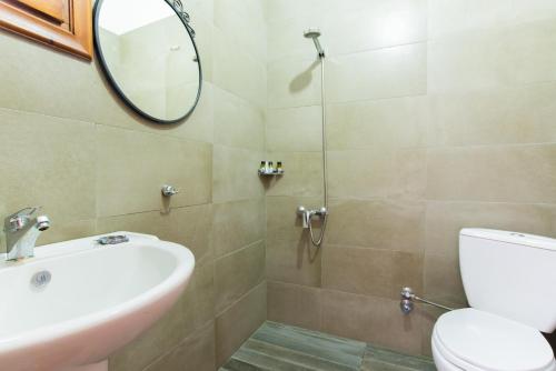 a bathroom with a sink and a toilet and a mirror at Platanorema in Agios Ioannis Prodromos
