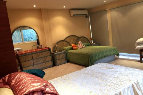a bedroom with two beds with a doll laying on it at La Naturaleza de Parque Leloir en Familia in Villa Leloir