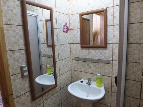 un baño con lavabo y dos espejos en Cabañas Vista Hermosa, en El Quisco