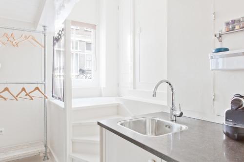 uma cozinha branca com um lavatório e uma janela em Luna's Hideaway em Amesterdão