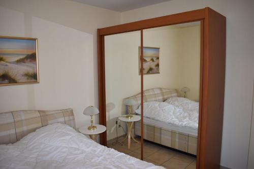 a bedroom with a mirror next to a bed at Anne Marie in Barendorf