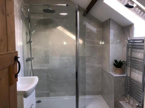 a bathroom with a shower and a sink at Little Coombe, Bookham Court in Dorchester