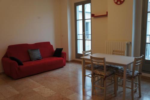 sala de estar con sofá rojo y mesa en A casa dalla Fra 2, en Castelfranco Emilia