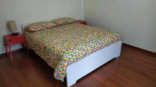 a bed with a colorful comforter in a room at A casa dalla Fra 2 in Castelfranco Emilia