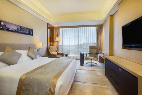a hotel room with a bed and a flat screen tv at Crowne Plaza Guangzhou Huadu by IHG - Free Shuttle bus between hotel to Exhibition Center During Canton Fair in Guangzhou