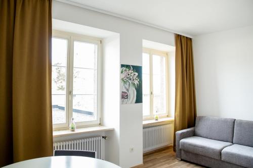 a living room with a couch and a table and windows at Apartment 7 in Stockach