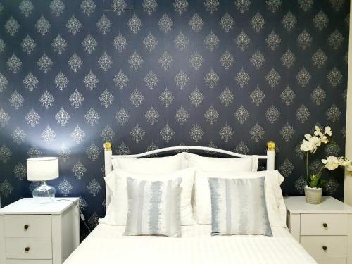 a bedroom with a white bed with a blue wall at kelly's House Plateau City Center in Praia