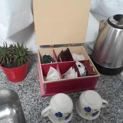 a box of china sitting on a counter next to two cups at Depto Temporario La Plata in La Plata