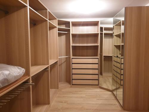 a walk in closet with wooden cabinets and glass doors at Maison villa de charme in Saasenheim