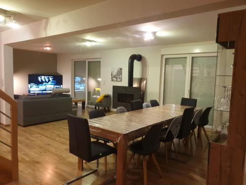 a dining room with a table and chairs and a living room at Maison villa de charme in Saasenheim