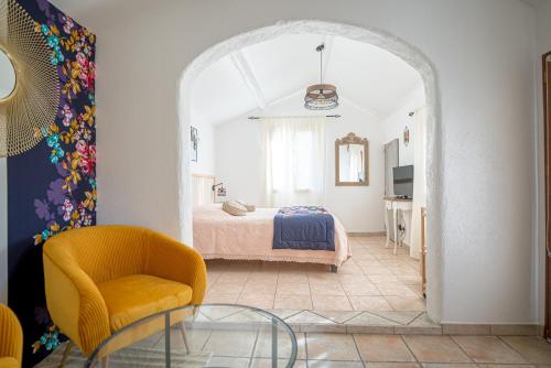 a bedroom with a bed and a chair and a glass table at A l'Orée du Pin in Puyricard