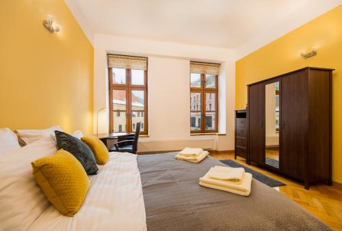 a bedroom with a large bed with yellow walls at Council Square eState Apartment *Bull's Eye* in Braşov