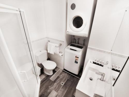 a small bathroom with a toilet and a sink at Quest on Eden Auckland CBD Apartment Hotel in Auckland
