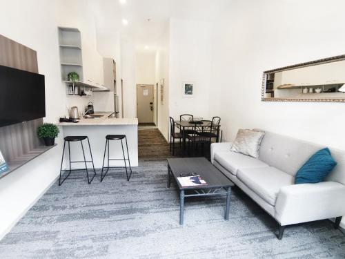 a living room with a couch and a table at Quest on Eden Auckland CBD Apartment Hotel in Auckland