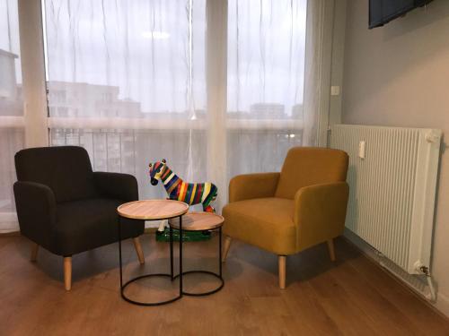 - un salon avec deux chaises, une table et un chien jouet dans l'établissement SAFARI DREAM, à Lille