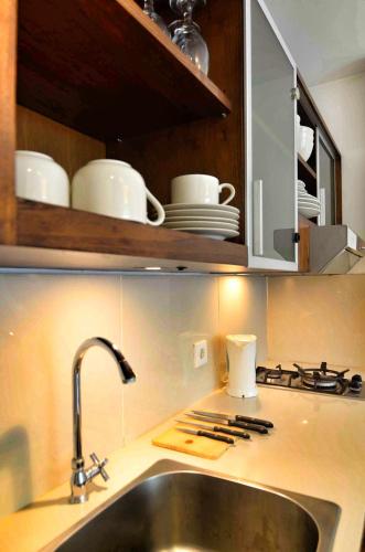 a kitchen with a sink and a counter with dishes at Sunset Residence and Condotel in Legian