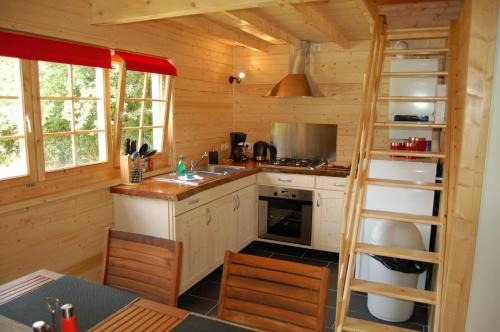 una cocina con escalera en una cabaña de madera en Ascou la Forge, en Ascou