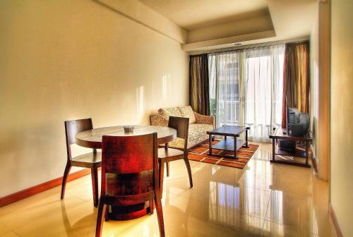 a living room with a table and chairs at Sunset Residence and Condotel in Legian