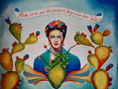 una pintura de una mujer sosteniendo una planta en Hostal Casa de Dante en Guanajuato