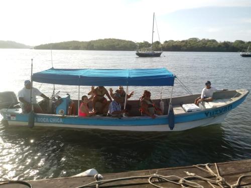 a group of people sitting on a boat in the water at Beached Bungalow Overlooking the Pacific Ocean in Boca Chica