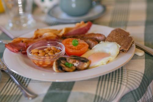 um prato de alimentos com ovos, bacon, tomate e feijão em Yew Tree Farm em Congleton