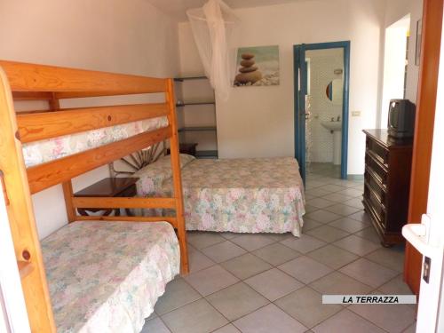 a bedroom with two bunk beds and a bathroom at Appartamenti Villa Lina in Nisporto