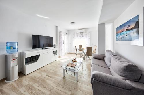 a living room with a couch and a tv at Sonrisa Apartments in Benidorm