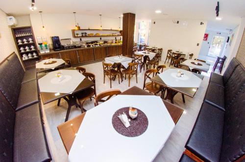 a restaurant with tables and chairs with a cake on top at Hotel Balneário do Parque in Penha