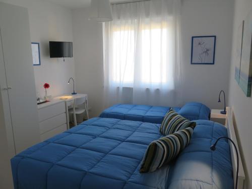 Schlafzimmer mit einem blauen Bett und einem Schreibtisch in der Unterkunft AnconaBed in Ancona