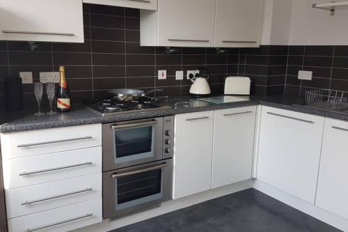 a kitchen with white cabinets and a stove top oven at Rutland View in Oakham